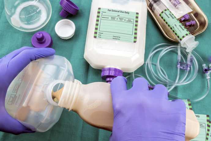 Enfermera prepara fórmula de nutrición enteral