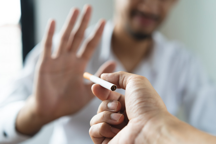 Hombre rechazando un cigarro al conocer los beneficios de dejar de fumar. 