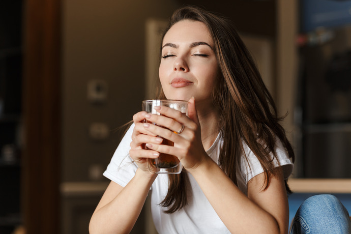 Mujer tomando una infusión de diente de león para disfrutar de sus beneficios.