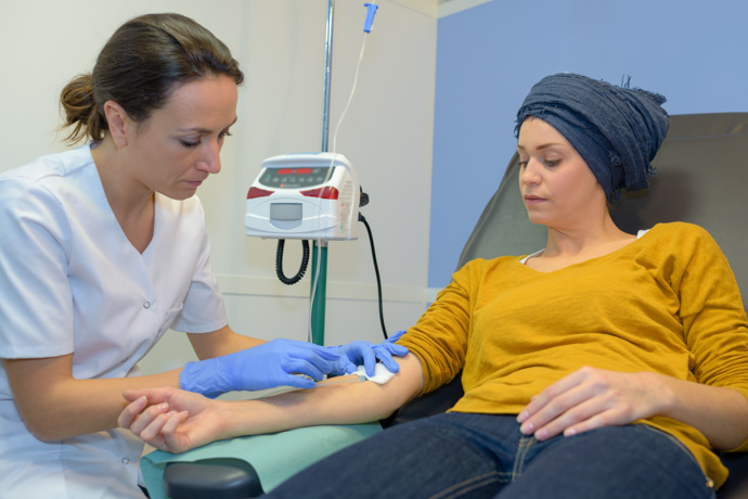 Mujer recibiendo tratamiento quimioterapia, diferente a la radioterapia.