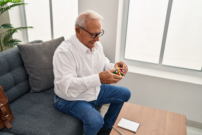 hombre mayor jugando a cubo de Rubik