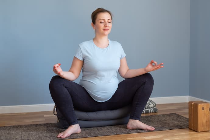 mujer en posición malasana haciendo yoga para embarazadas