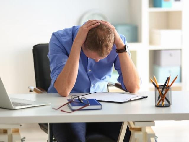 hombre con mala salud mental en el trabajo