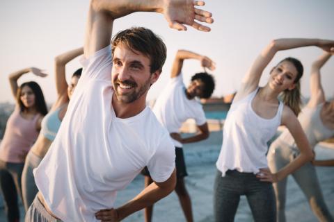 Grupo de personas jóvenes y deportistas haciendo estiramientos al aire libre