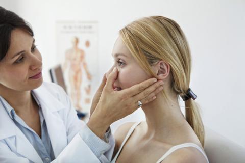 Dermatólogo revisa grano en nariz